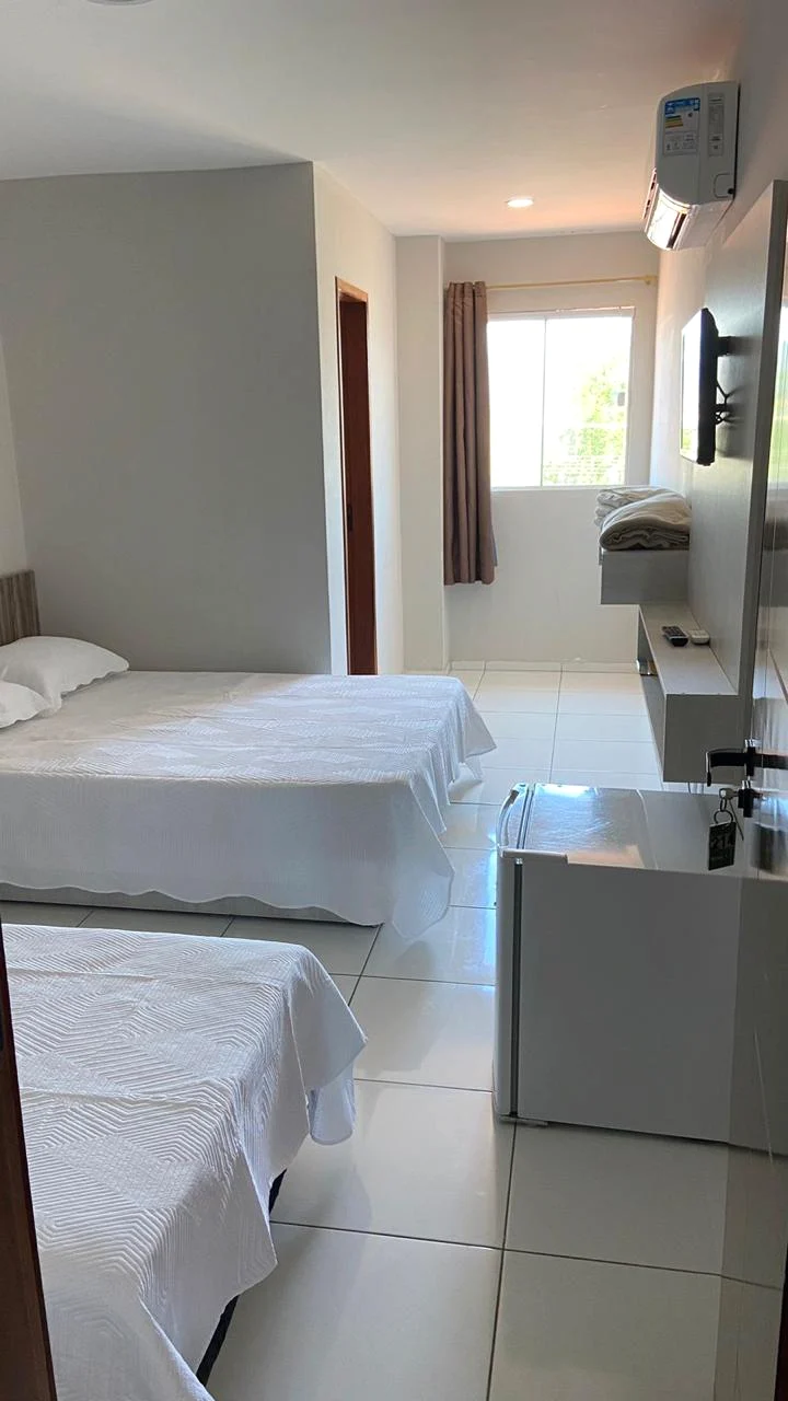 Quarto com ar-condicionado, televisão e frigobar