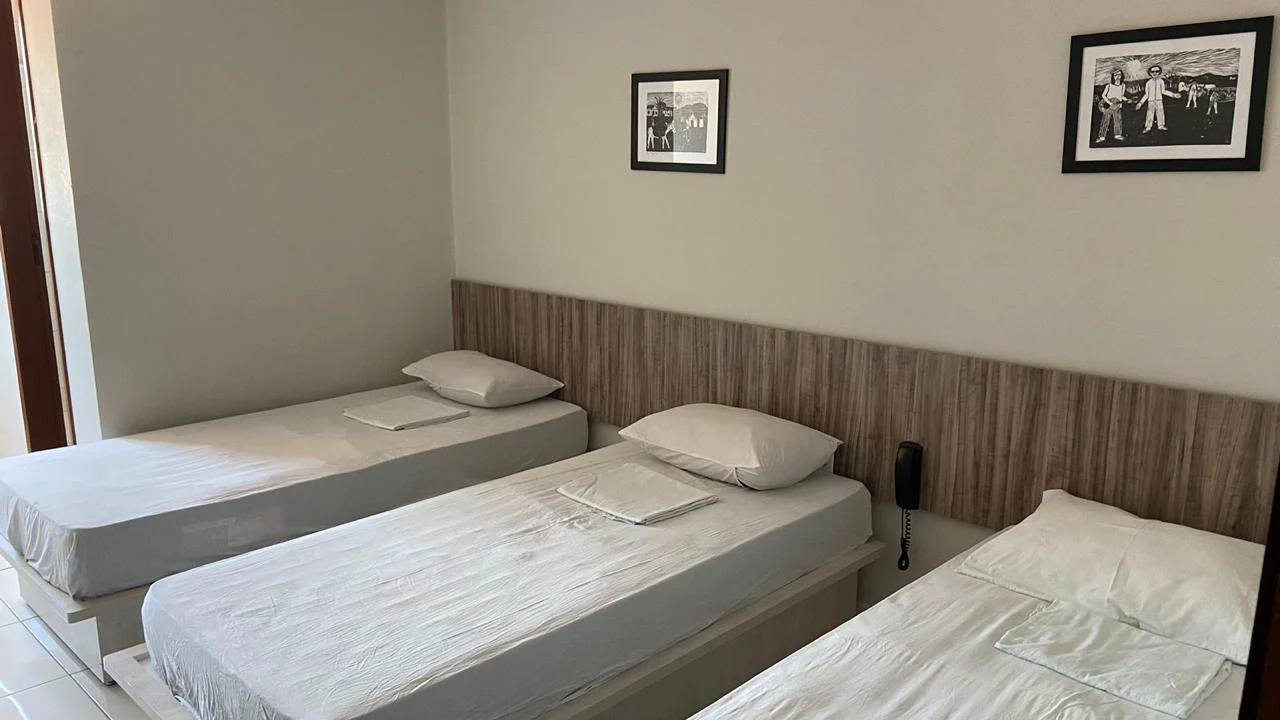 Acomodação com camas individuais e piso cerâmico claro